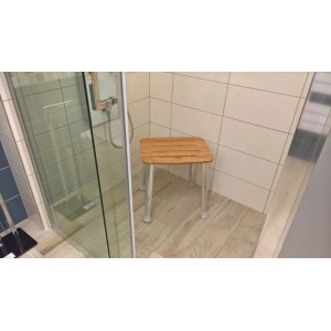 Höhenverstellbarer Duschhocker mit Bambussitz und Aluminiumbeinen in einer modernen Duschkabine. Ideal als Badhelfer.