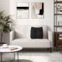 Schwarzes Samt-Rückenkissen auf hellem Sofa. Komfortables Kissen für Rückenunterstützung im Wohnzimmer.