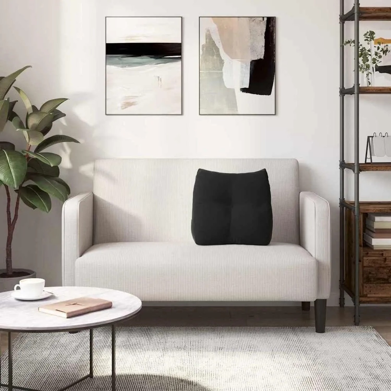 Schwarzes Samt-Rückenkissen auf hellem Sofa. Komfortables Kissen für Rückenunterstützung im Wohnzimmer.