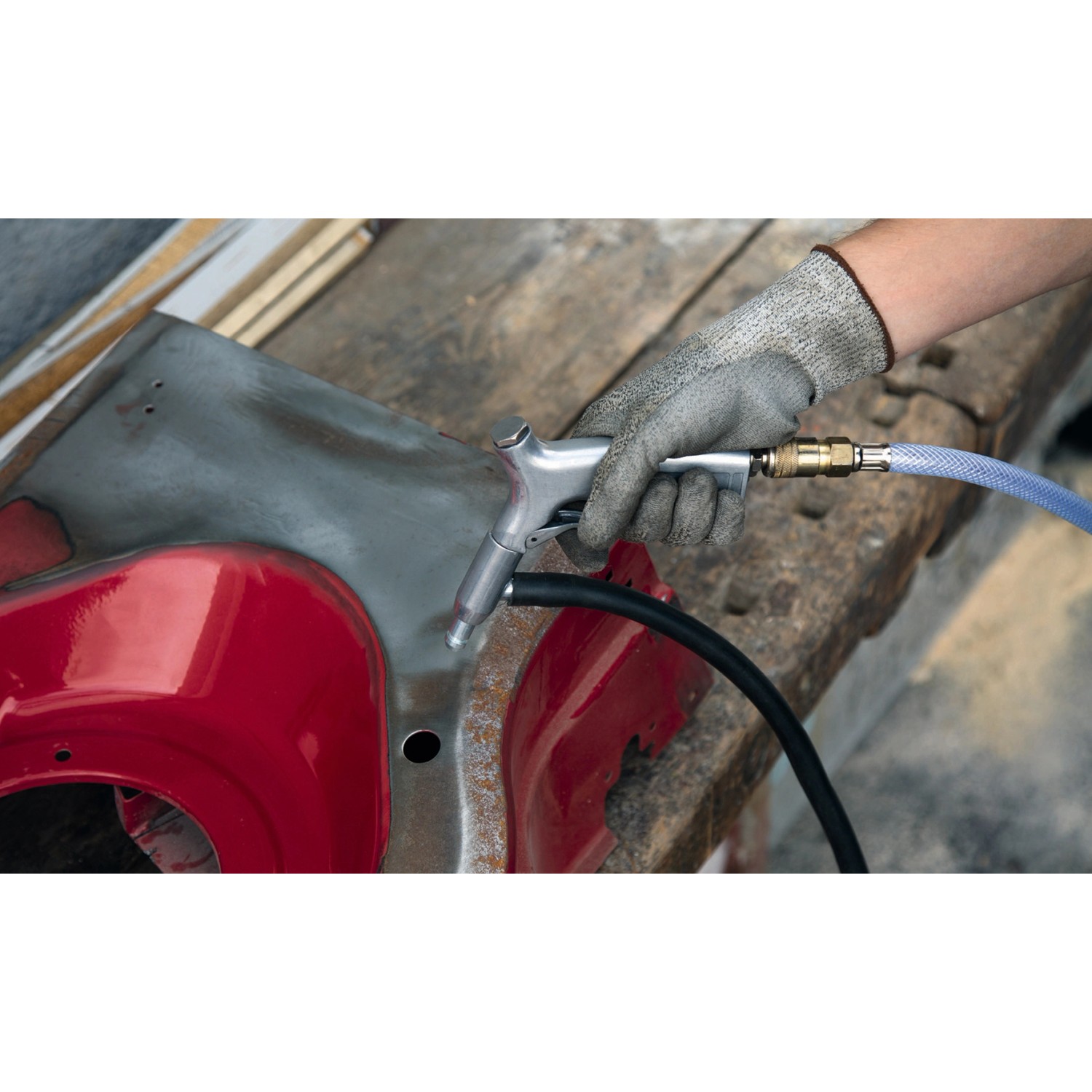 Einhell Druckluft-Saugstrahlpistole in Aktion beim Entrosten eines Werkstücks. Zubehör für Kompressoren.