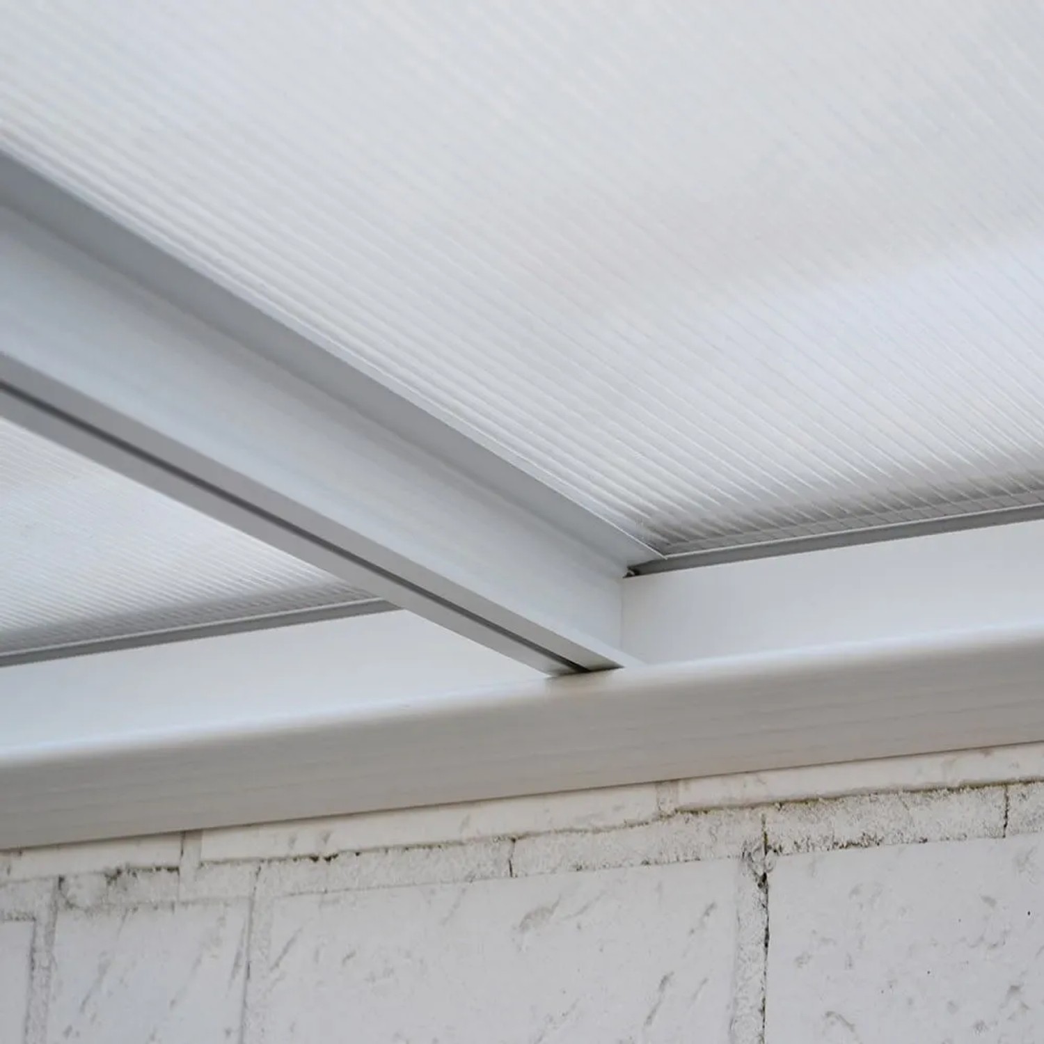 Detailansicht der weißen Home Deluxe Terrassenüberdachung Solis aus Aluminium und Hohlkammerplatten.