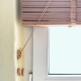 Schwarze Sol Royal Holzjalousie (B130xH250cm) am Fenster mit Zugschnüren.