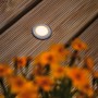 Runder Paulmann LED Bodeneinbaustrahler auf Holzterrasse, insektenfreundlich und mit warmem Licht.