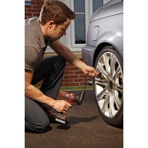Mann pumpt Autoreifen mit Black+Decker Multievo Kompressor-Kopf auf.