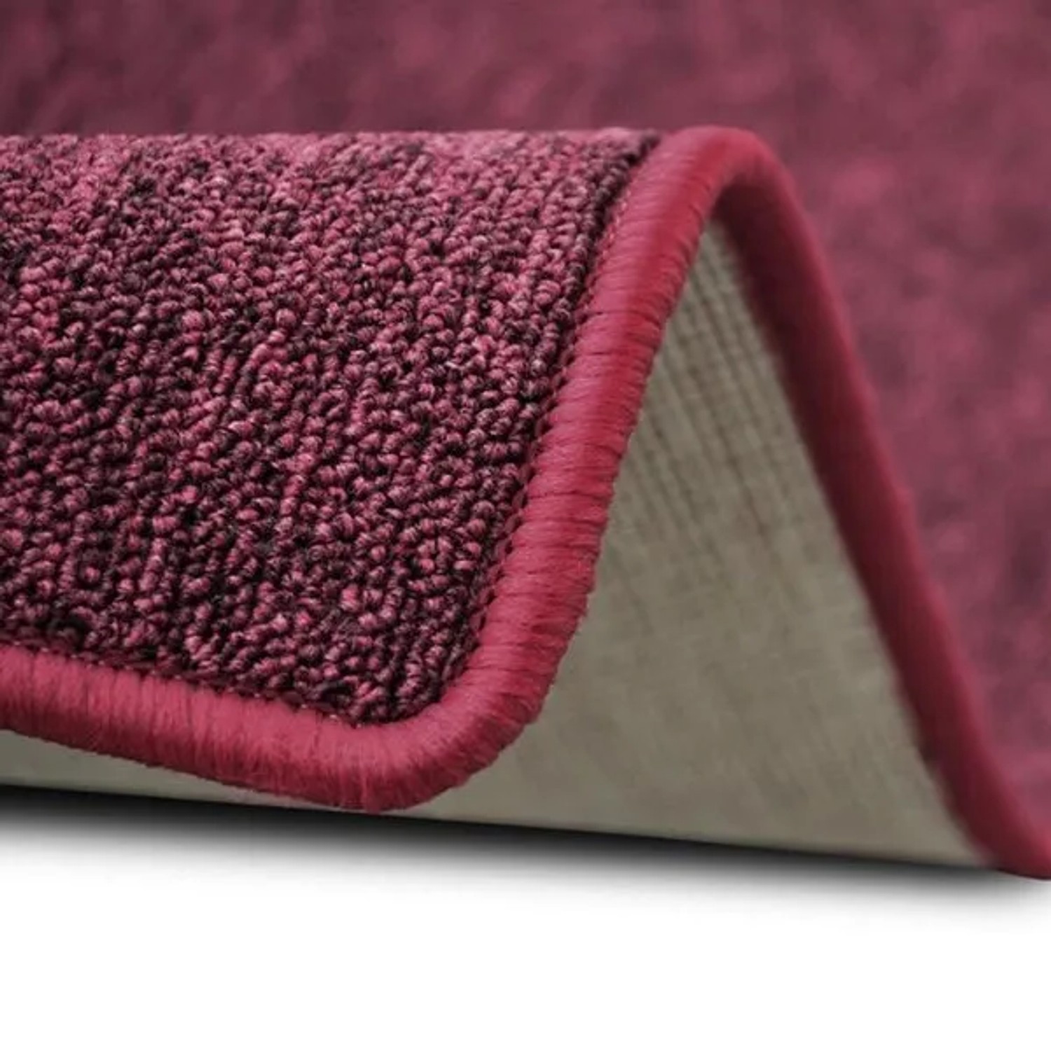 Detailaufnahme: Weinroter Karat Teppich London mit Schlingenflor und farblich passender Umkettelung.