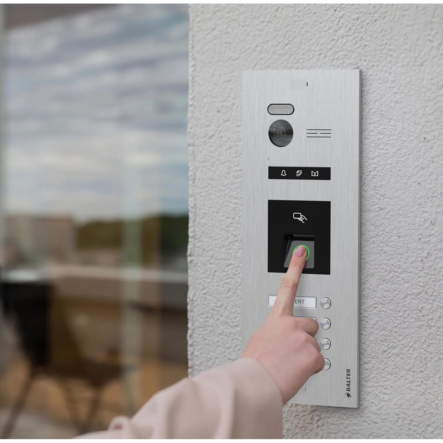 Balter EVO-HD Video-Türsprechanlage, silber-schwarz, an Hauswand. Hand nutzt Fingerprint-Sensor zur Türöffnung.