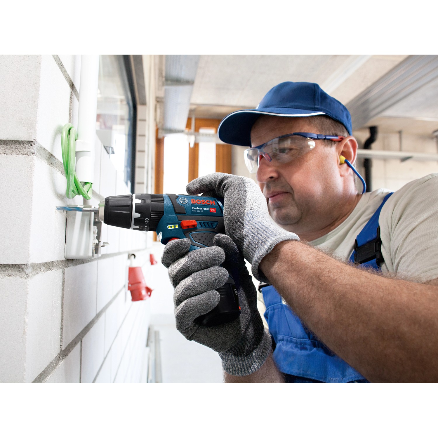 Bosch Professional Akku-Schlagbohrschrauber GSB 12V-15 im Einsatz beim Bohren in eine Wand.