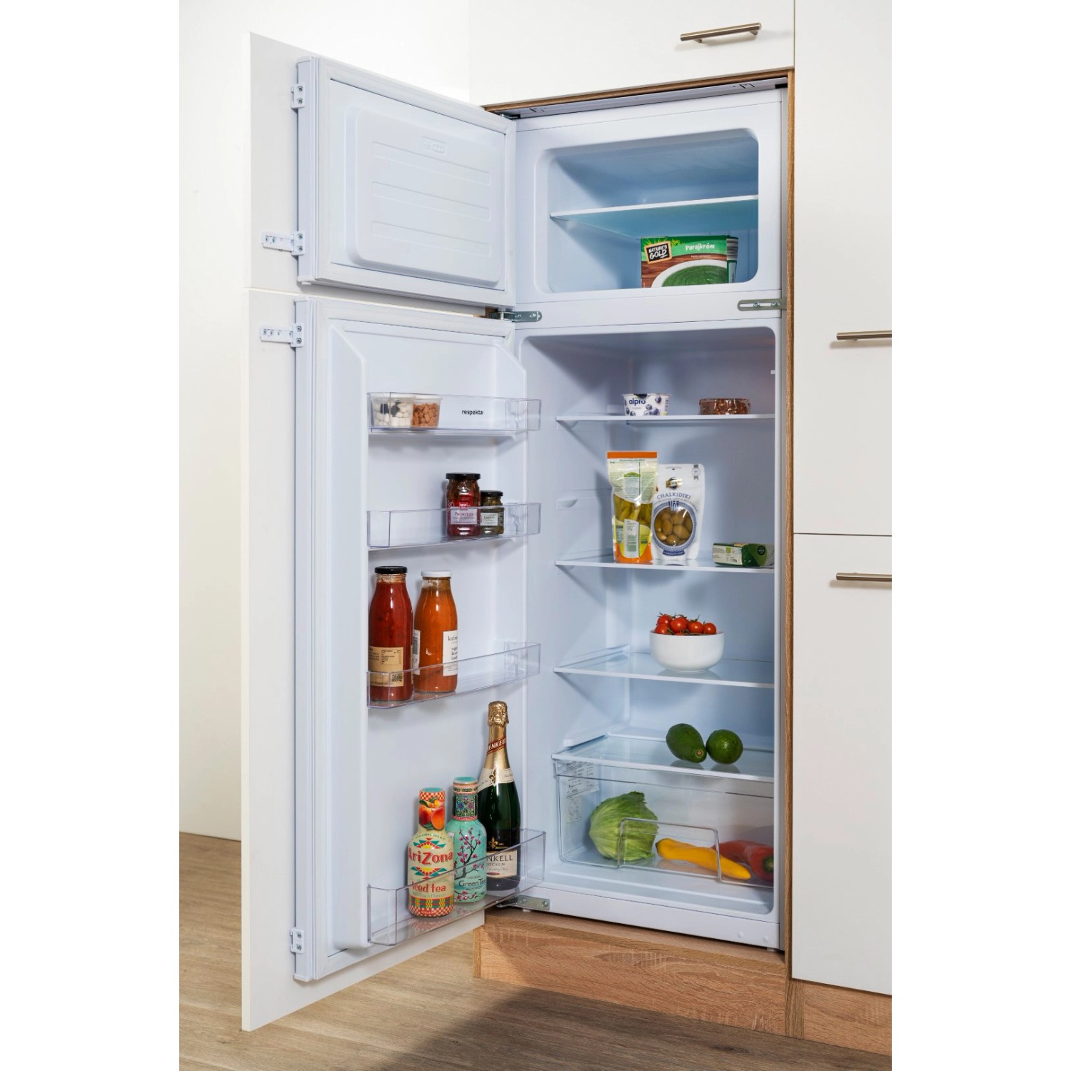 Geöffneter, weißer Einbaukühlschrank der Respekta Küchenzeile mit Lebensmitteln.