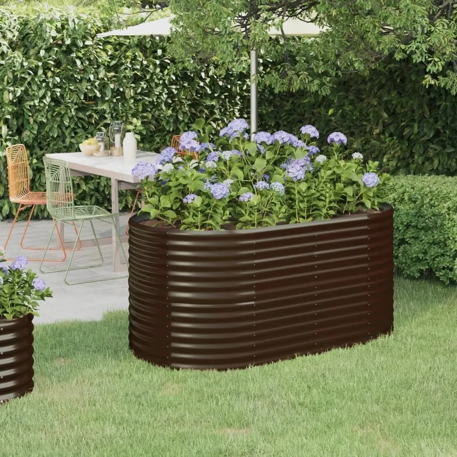 Braunes Furnicato Hochbeet aus verzinktem Stahl mit blühenden Pflanzen im Garten.