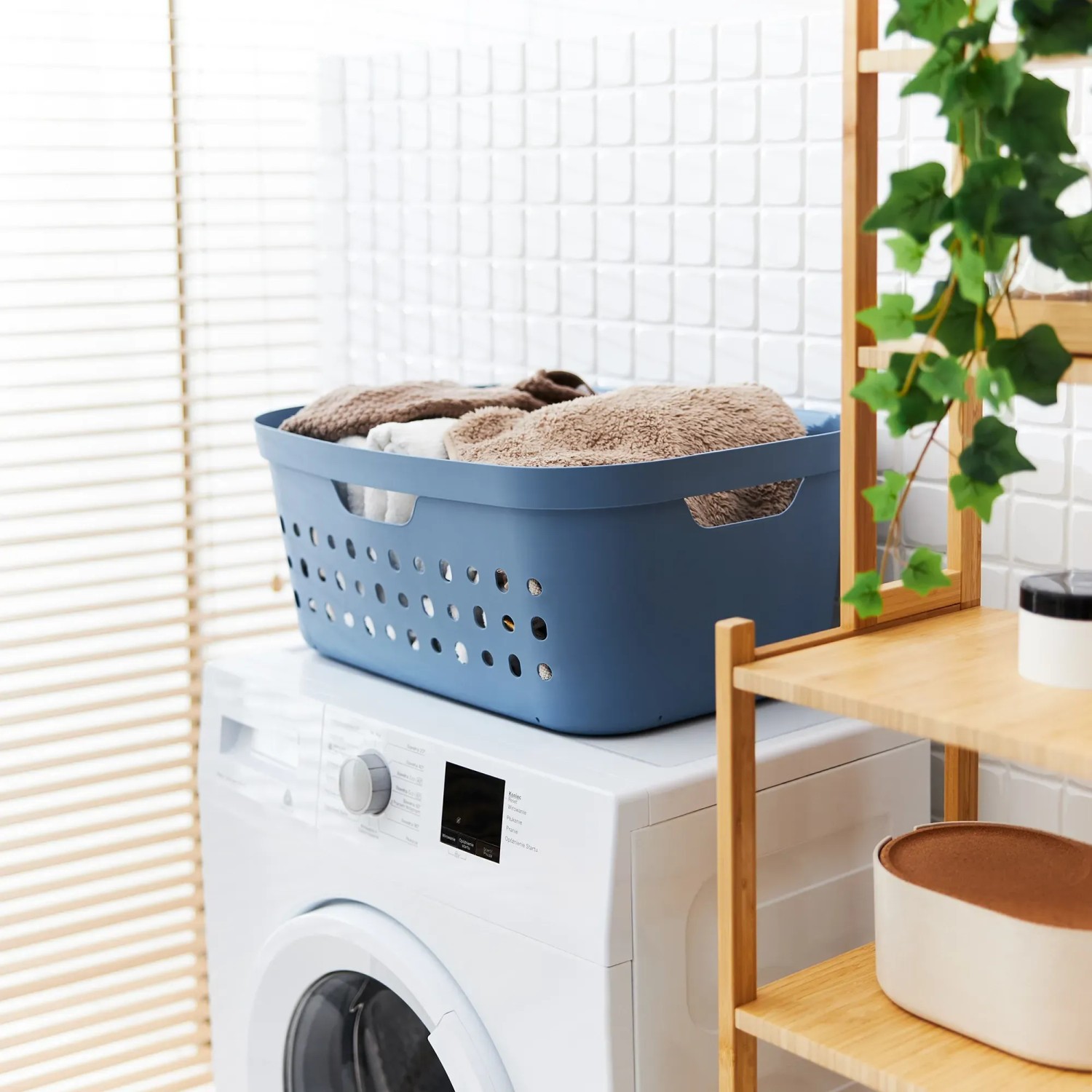Blauer Rotho Wäschekorb Jona 39L auf Waschmaschine mit Wäsche. Praktischer Wäschekorb.