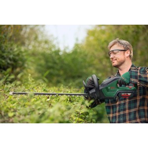 Mann schneidet Hecke mit Bosch Akku-Heckenschere AdvancedHedgeCut 36 V-65-28. 