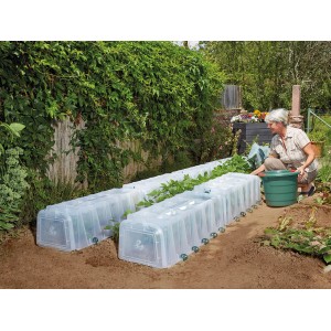 Garantia Sunny Pflanztunnel im Garten mit Frau beim Gießen. Frühbeet für beschleunigtes Wachstum.