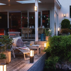 Philips Hue Impress: Schwarze LED-Wandlampe mit Farbwechsel für den Außenbereich, montiert an Hauswand und als Wegeleuchte.