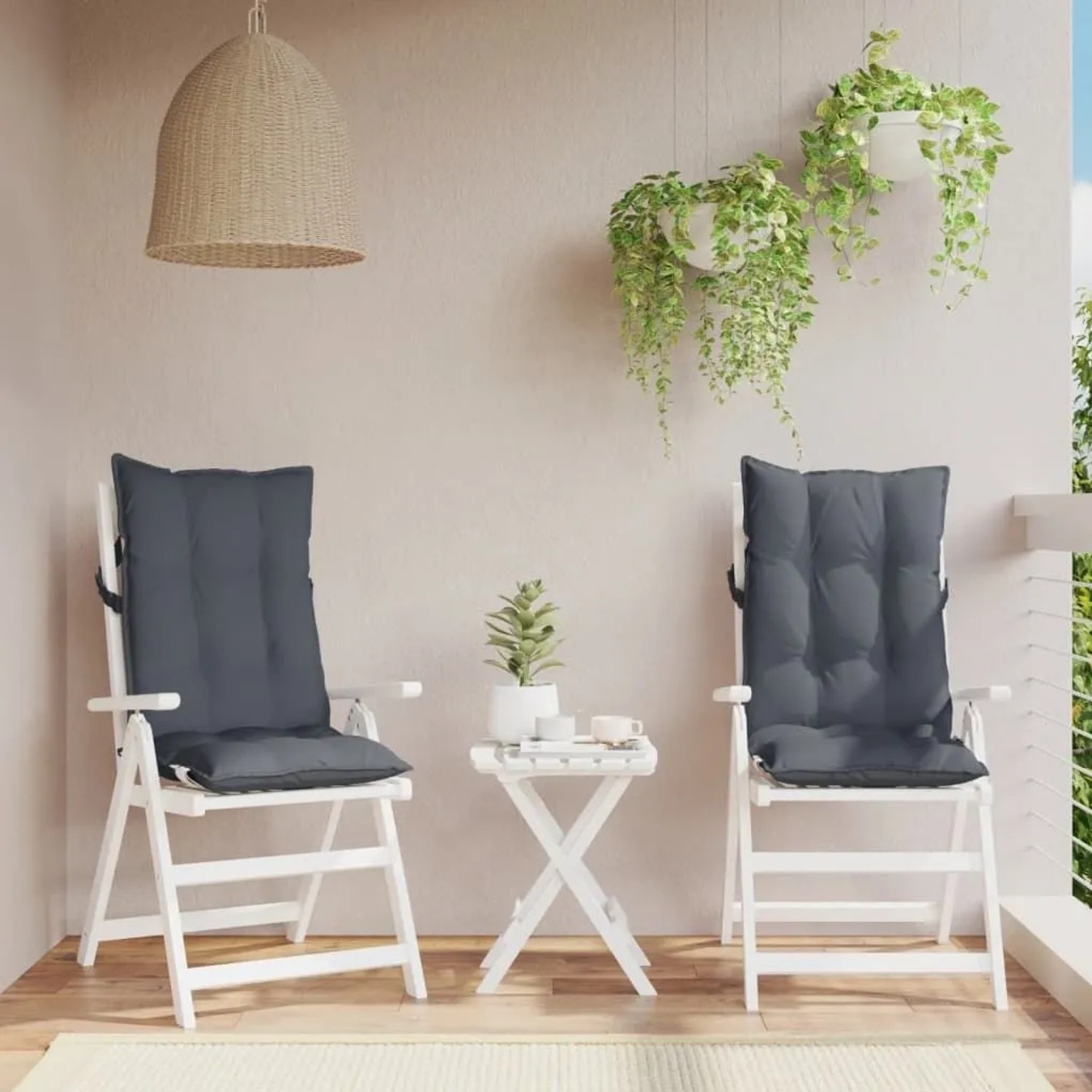 Zwei anthrazitfarbene Hochlehner-Auflagen aus Oxford-Gewebe auf weißen Gartenstühlen. Komfortable Sitzkissen für Outdoor.