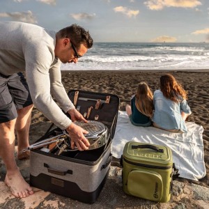 Petromax Camping-Box Catago mit Inhalt am Strand. Camping & Zubehör für Outdoor-Abenteuer.