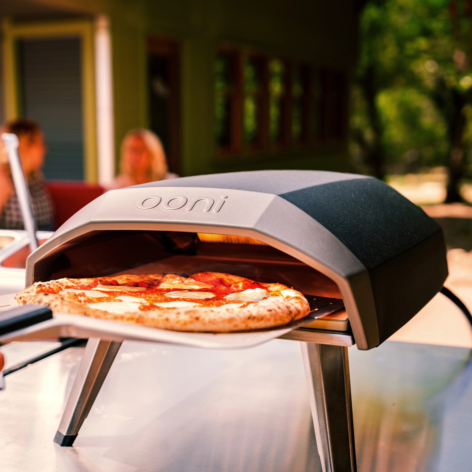 Ooni Koda 12 Gas-Pizzaofen mit Pizza auf Pizzaschieber. Kompakter Ofen für den Garten.
