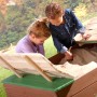 Axi Ella Sandkasten aus Holz, braun und grün, mit zwei spielenden Kindern.