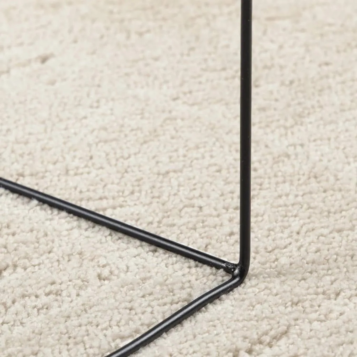 Beiger Kurzflor-Teppich OVIEDO aus weichem Polyester, Detailansicht der dichten Florfasern mit schwarzem Metallgestell.