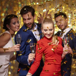Lachende Menschen feiern mit goldenem Konfetti und Sektgläsern. Ideal für Party Popper Gold, Hochzeit, Geburtstag, Silvester.