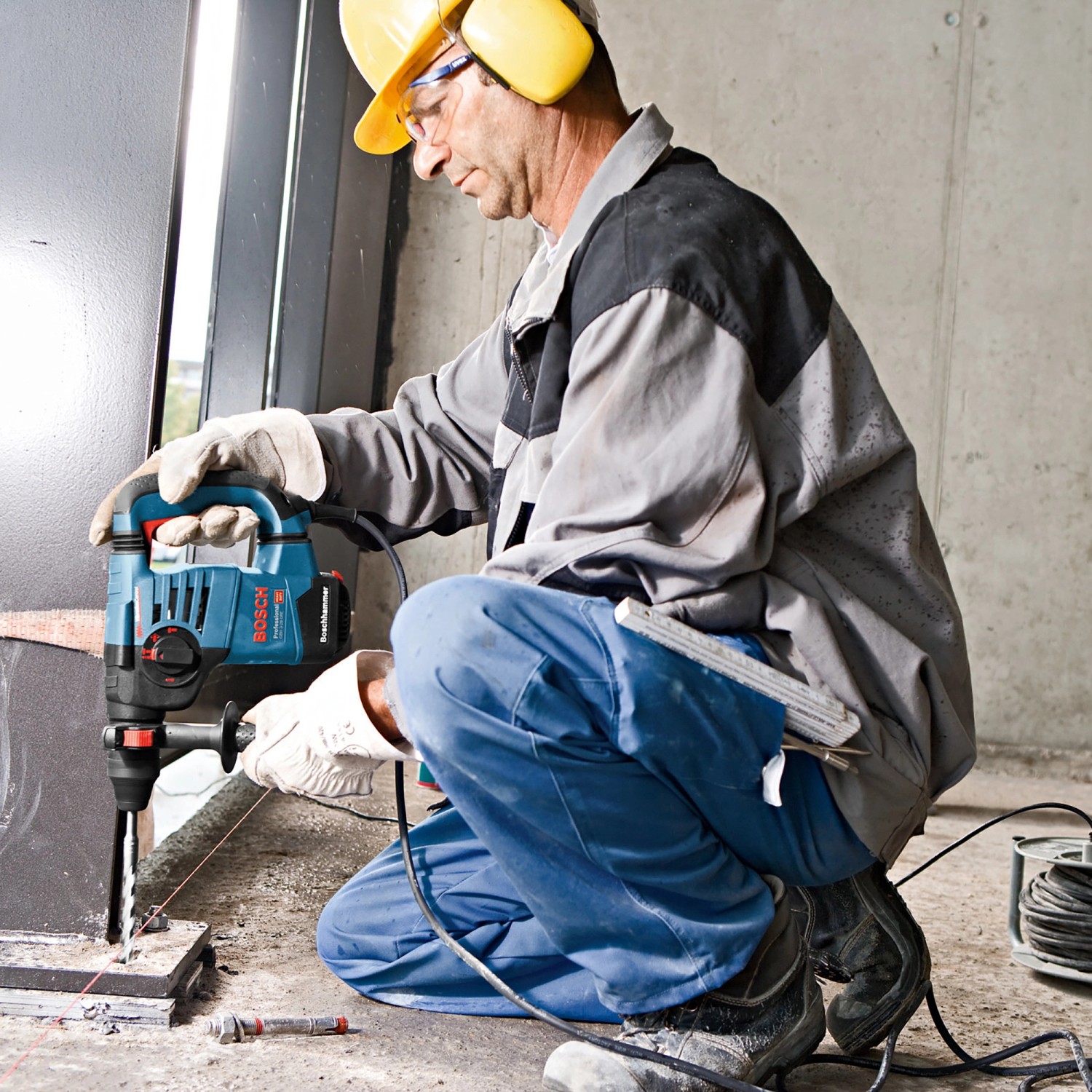 Handwerker bohrt mit dem Bosch Professional Bohrhammer GBH 3-28 DFR ein Loch in Beton.