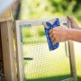 LUX Handtacker Classic beim Befestigen von Drahtgitter an einem Holzrahmen.