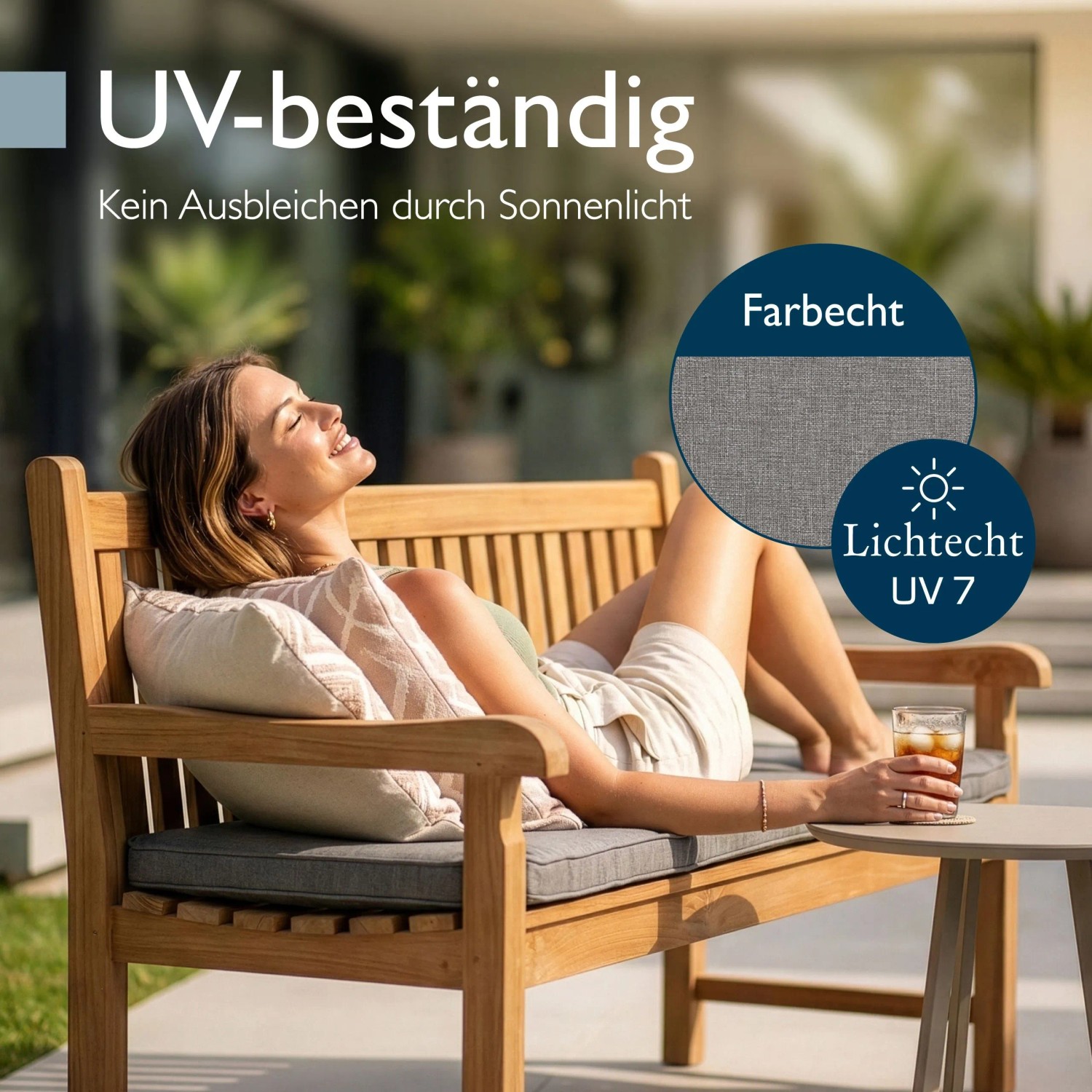 Hellgraue Beautissu Outdoor Bankauflage auf Holzbank, Frau entspannt im Garten. UV-beständig, waschbar, mit Fleckenschutz.