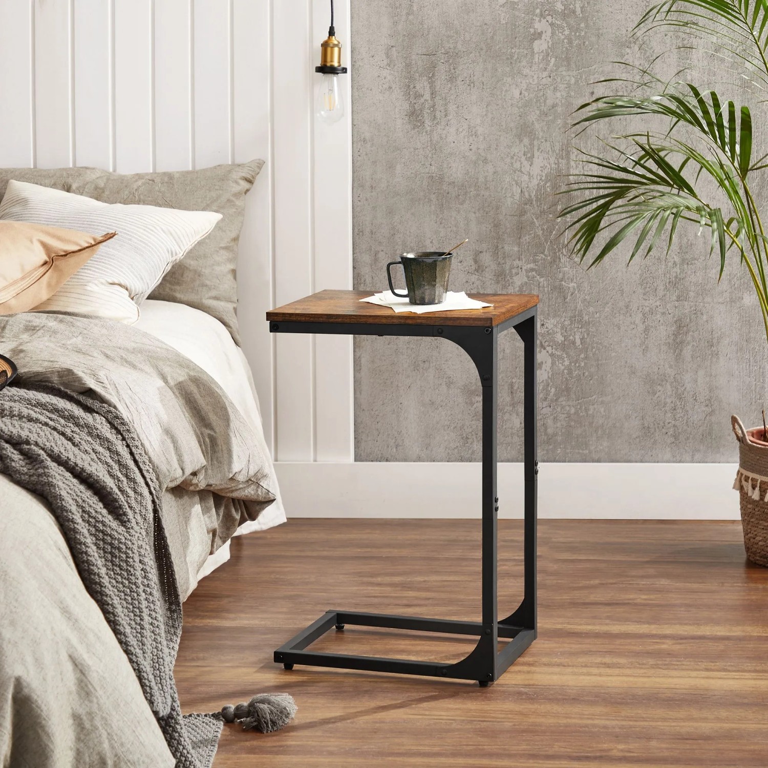 Vasagle Beistelltisch in C-Form, braun-schwarz, neben Bett mit Tasse.