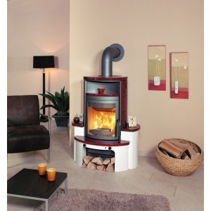 Hark Avenso GT ECOplus Kaminofen in Bordeauxrot mit Ofenkacheln und Holzscheiten im Wohnraum.