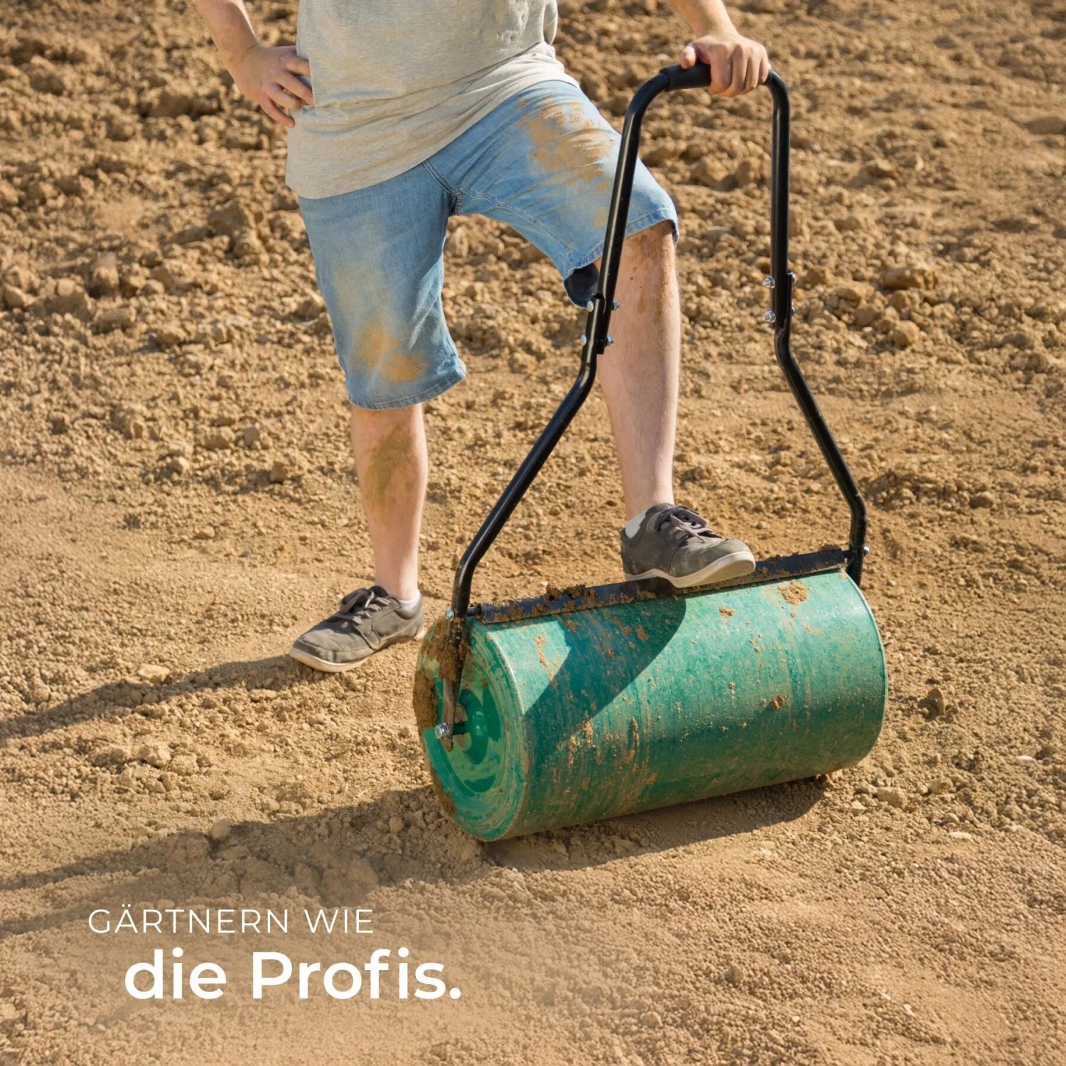 Grüne Tectake Rasenwalze (60 cm) im Einsatz auf einem Acker.