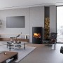 Schwarzer Justus Kaminofen Agero W+ (7 kW) im Wohnraum mit Holzstapel.