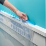 ScotchBlue Malerabdeckfolie mit Klebeband wird an einer Wand angebracht.