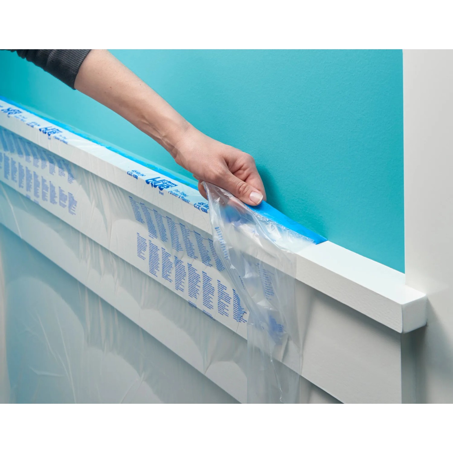 ScotchBlue Malerabdeckfolie mit Klebeband wird an einer Wand angebracht.