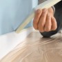 Anwendung von Tesa Malerband Classic (50mm) zum Abkleben einer Fußleiste vor dem Streichen.