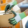 Hände mit LUX Arbeitshandschuhen Eco Gr. 10 beim Falten eines Kartons.