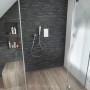 Badezimmer mit schwarzem Verblender UltraStrong Bologna Schiefer Feinsteinzeug an der Wand.