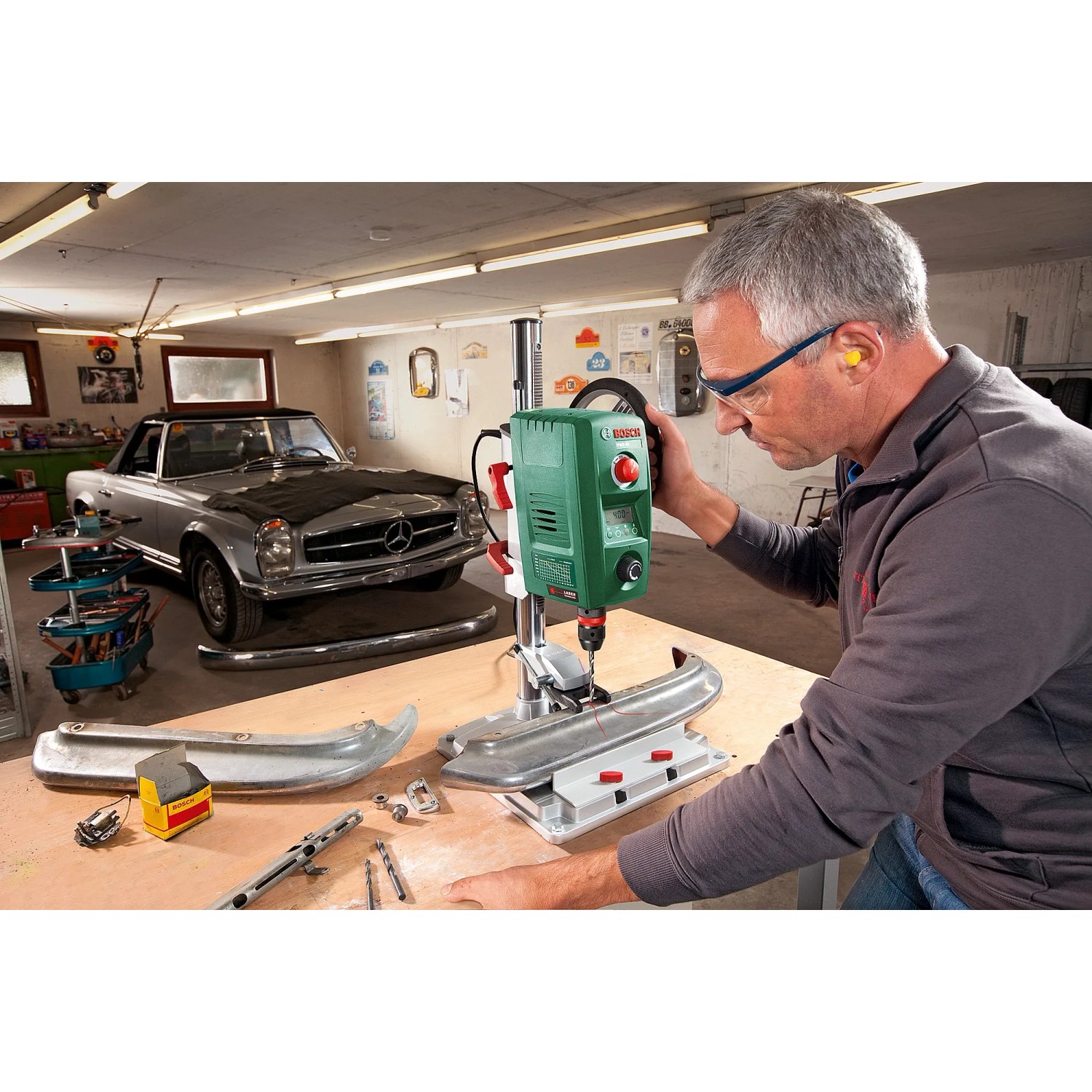 Bosch PBD 40 Tischbohrmaschine in Werkstatt mit Mann beim Bohren eines Werkstücks.