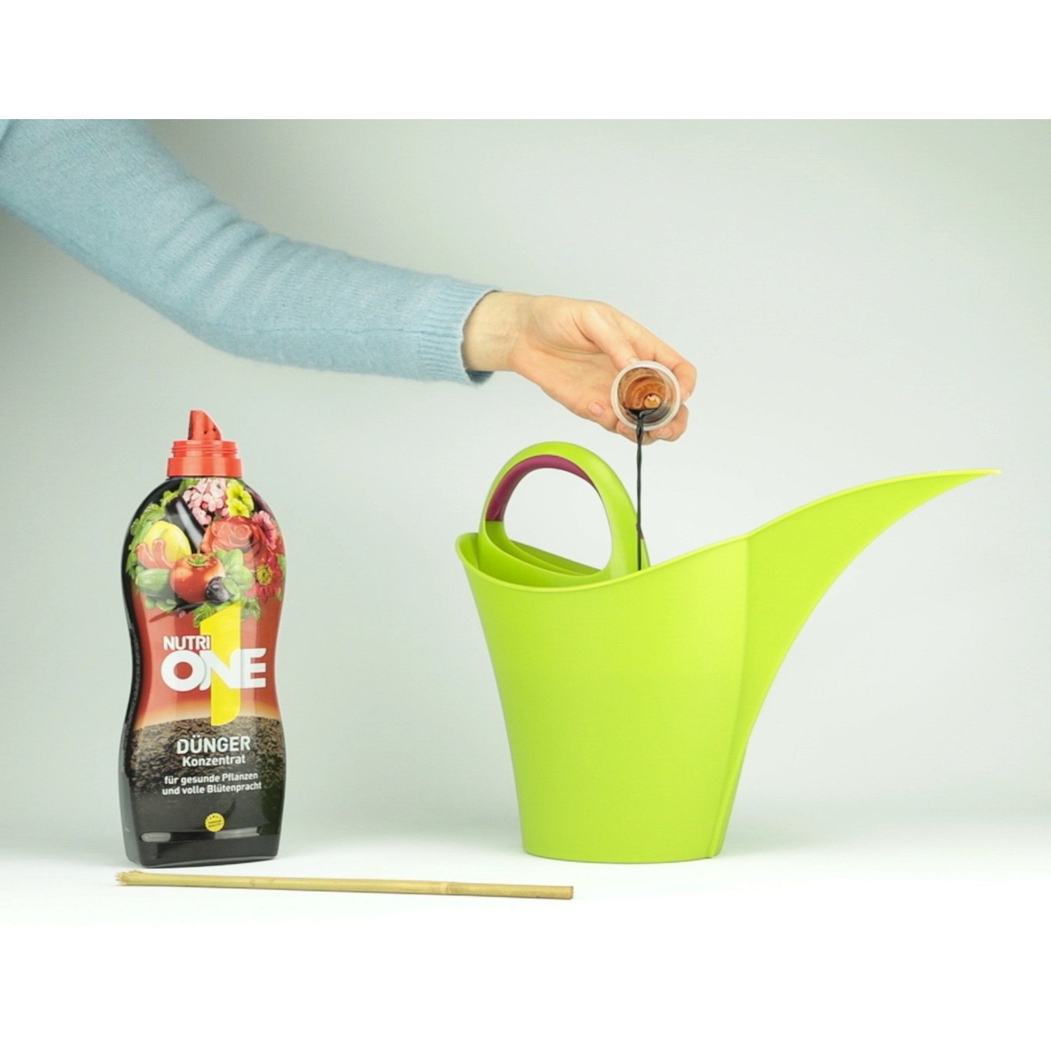 Nutri One Universal-Dünger wird in eine grüne Gießkanne gefüllt.