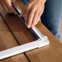 Montage des weißen Tesa Fliegengitter-Tür Falt Aluminiumrahmens auf einem Holztisch.