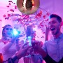 Silberne Discokugel (30 cm) aus Glas, Kunststoff und Metall unter Partygästen mit Konfetti.