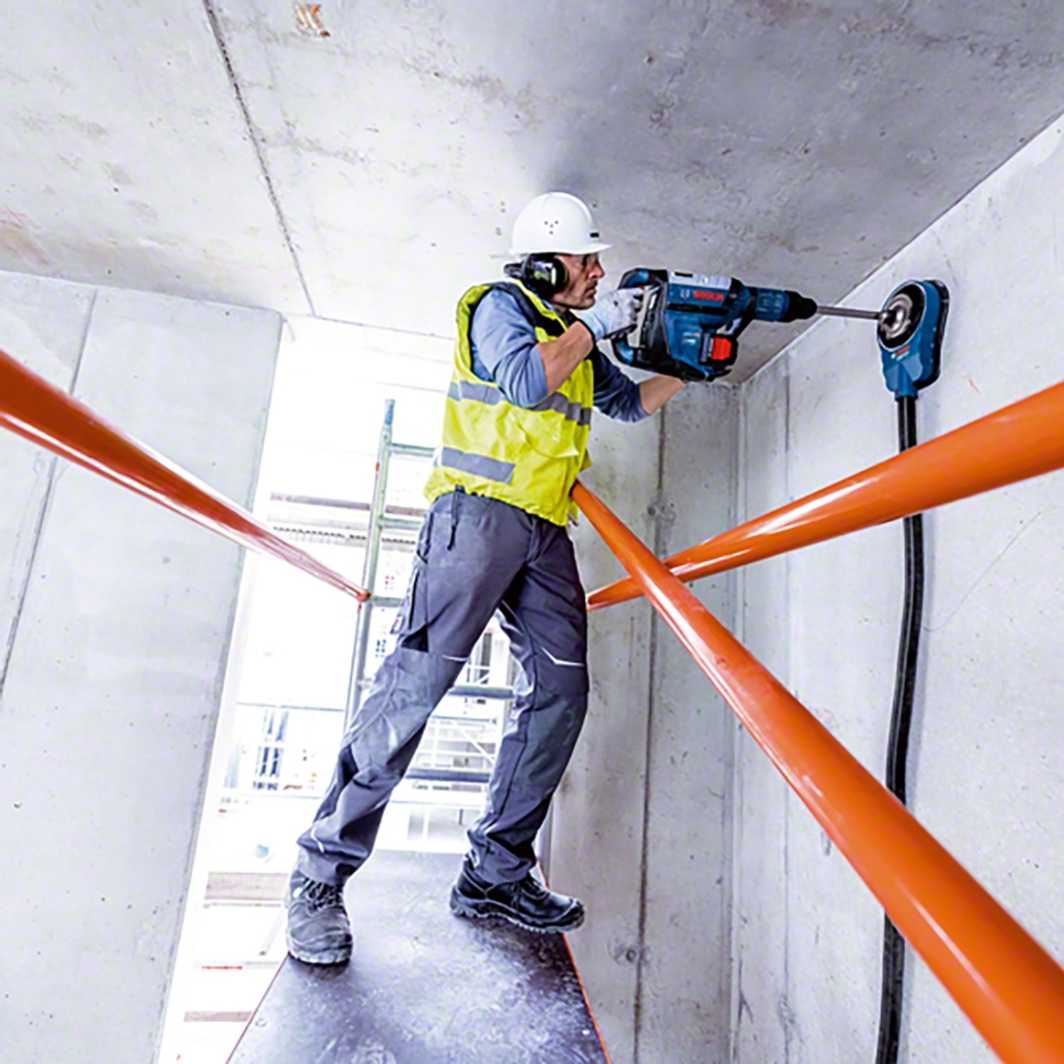 Handwerker bohrt mit dem Bosch Professional Akku-Bohrhammer GBH 18V-45 C in Beton.