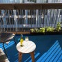 Blauer Primaflor Rasenteppich Park auf Balkon mit Tisch und Stuhl.