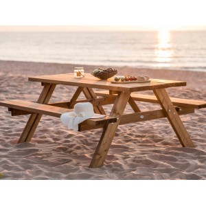 Axi Picknicktisch Julie aus Holz, braun, mit Speisen und Hut am Strand.