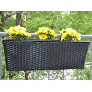 Rechteckiger, schwarzer Polyrattan Pflanzkübel (60cm) mit gelben Blumen am Balkongeländer.