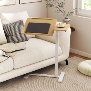 Höhenverstellbarer Pflegetisch in Holzoptik mit weißem Gestell, neigbarer Platte für Laptop, fester Ablage für Tasse, am Sofa.