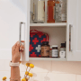Weißes Yale Möbelschloss Smart Cabinet Lock mit Bluetooth an weißem Schrank.