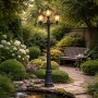 Schwarze QAZQA Außenlaterne New Haven mit 3 Lampen im Garten.