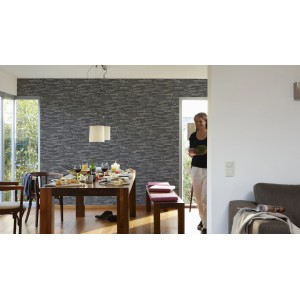 Wohnraum mit schwarzer Vliestapete Naturals in Steinoptik. Dekorative Tapete für ein natürliches Ambiente.