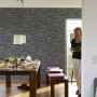 Wohnraum mit schwarzer Vliestapete Naturals in Steinoptik. Dekorative Tapete für ein natürliches Ambiente.