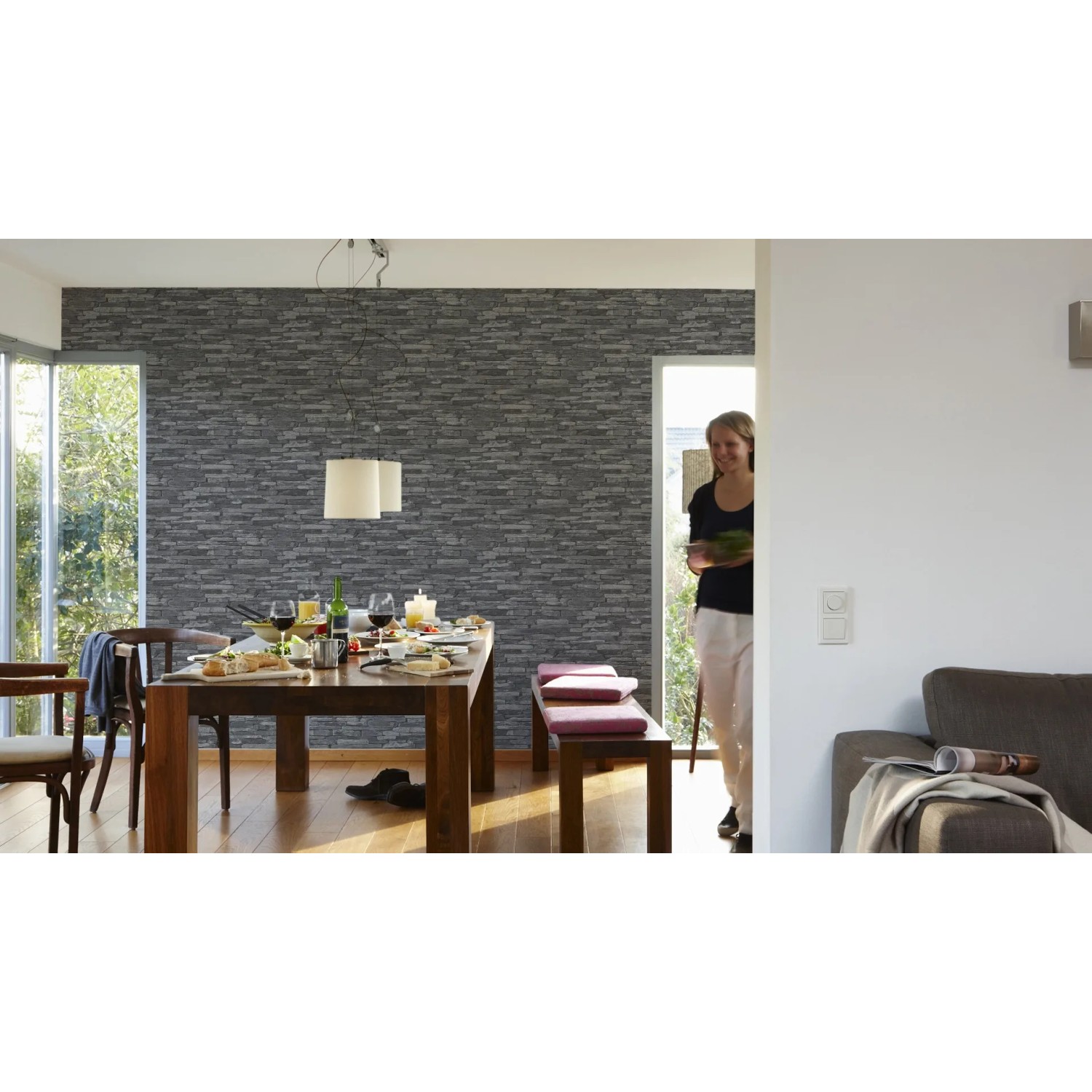 Wohnraum mit schwarzer Vliestapete Naturals in Steinoptik. Dekorative Tapete für ein natürliches Ambiente.
