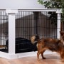 Weiße Hundebox Indoor mit Tischoberfläche und kleinem Hund davor.
